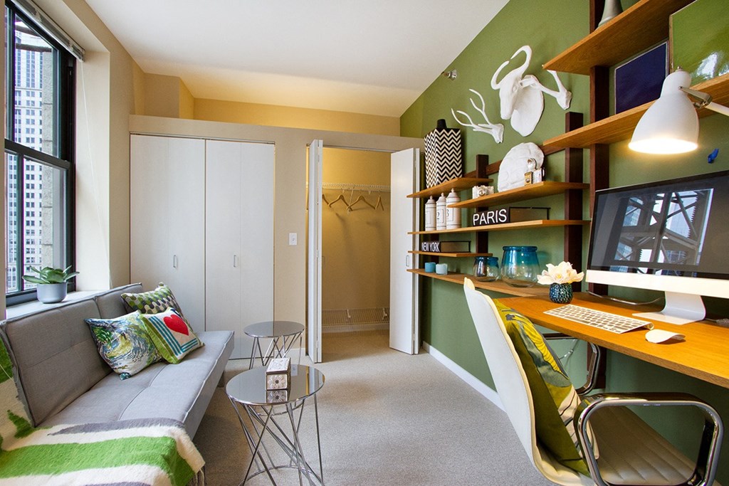a living room with a couch and a desk with a computer