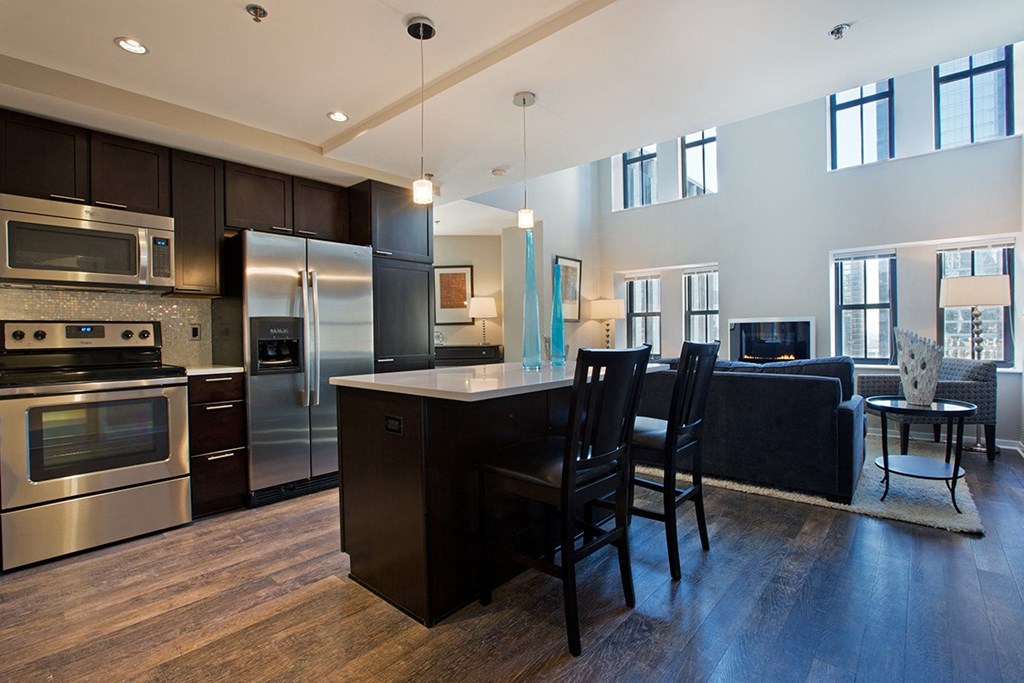 a kitchen with stainless steel appliances and an island with chairs