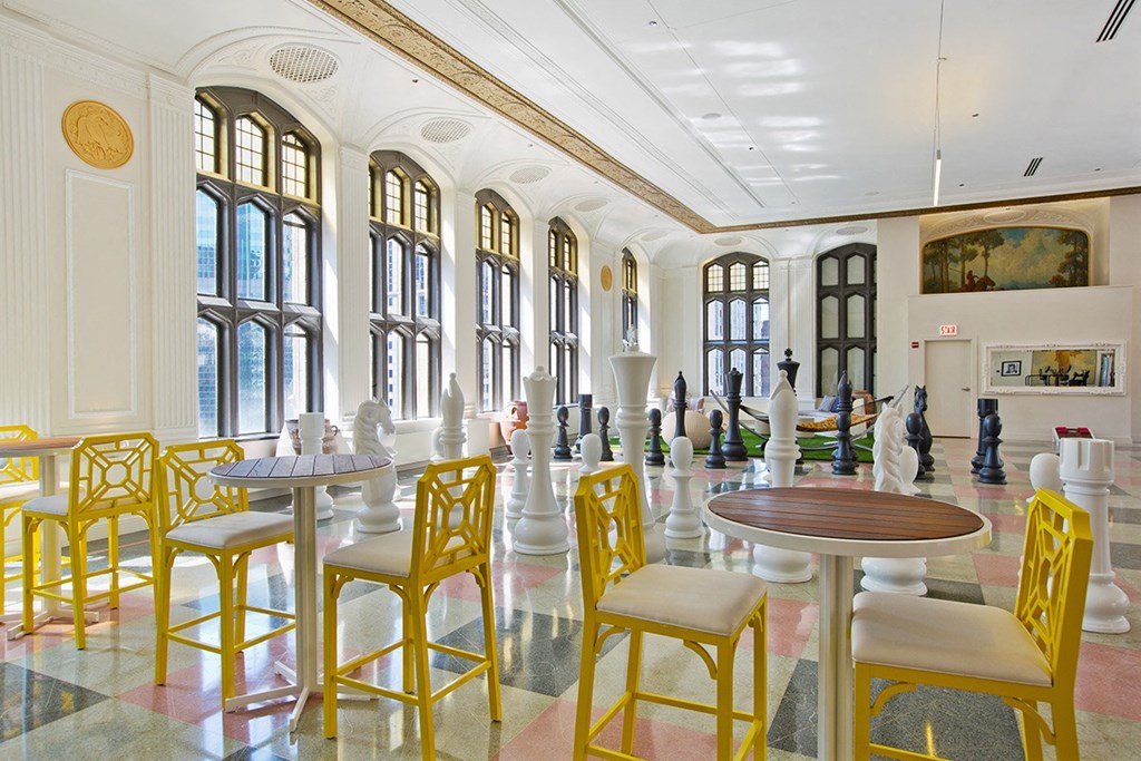 a large lobby with tables and chairs and chess pieces