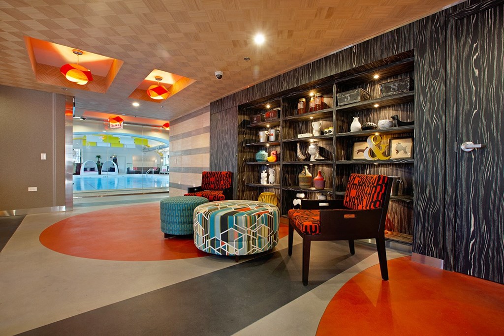 the lobby of a hotel with furniture and a glass door