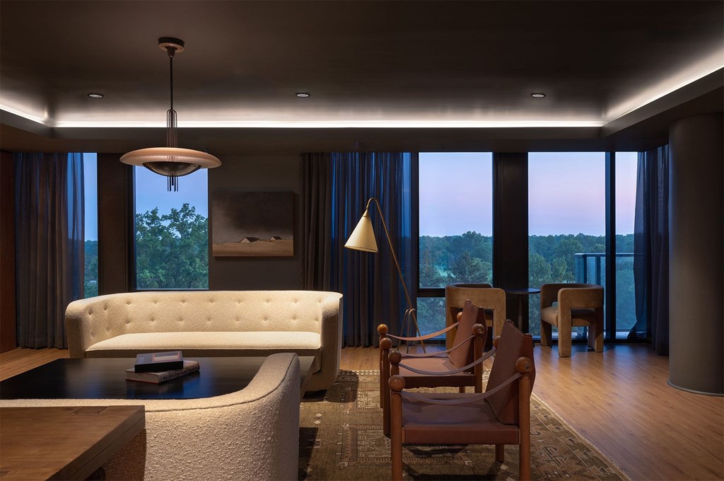 A modern living room with a white sofa and wooden chairs.