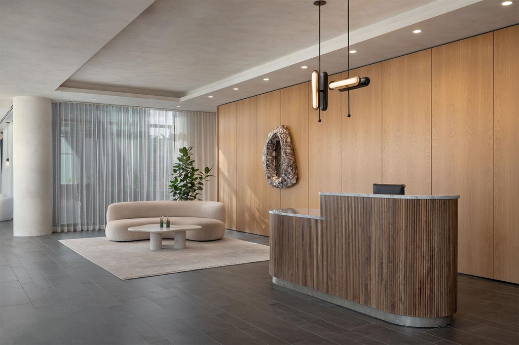 A reception area with a wooden reception desk and a white sofa.