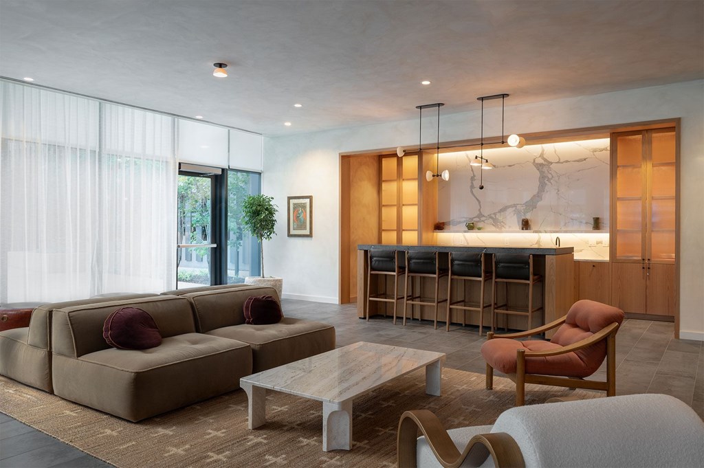 A modern living room with a large couch, a chair, and a coffee table.