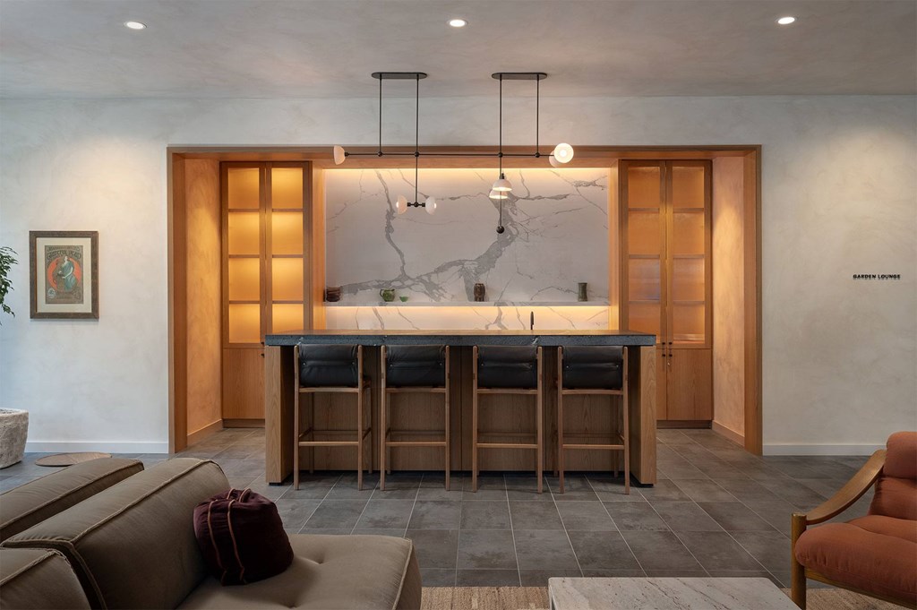 A modern kitchen with a central island and a dining table set for four.