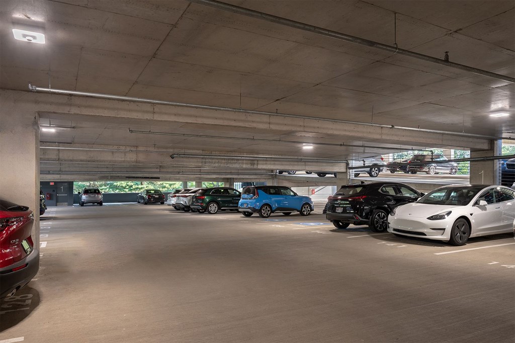 A parking garage with several cars parked in it.