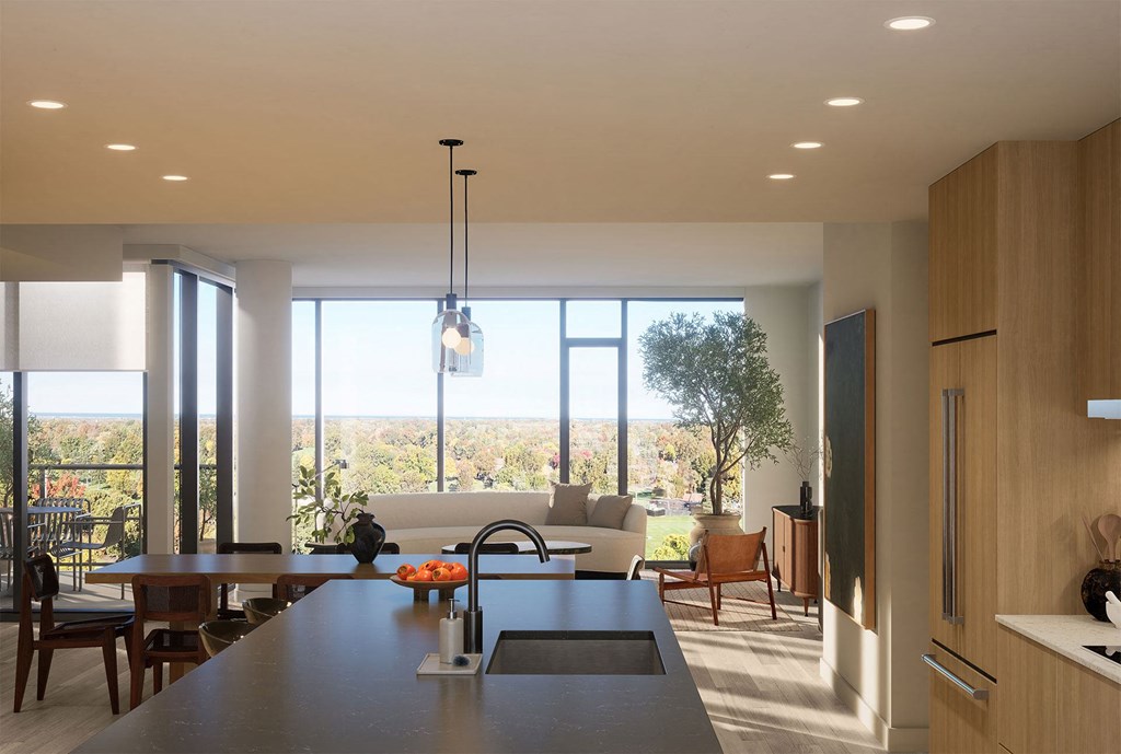 the kitchen and living room of a modern house with large windows