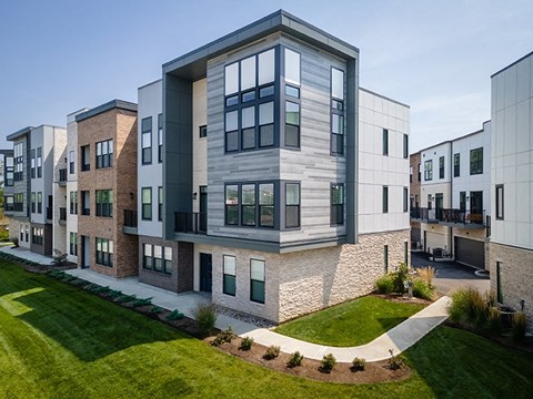 A modern apartment complex with a mix of brick and stone exteriors.