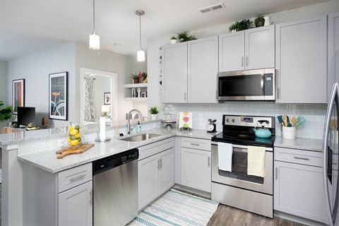 A kitchen with white cabinets and stainless steel appliances.
