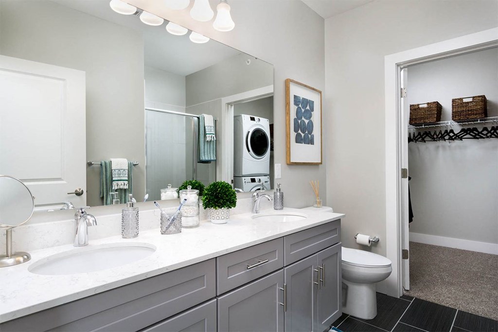 A bathroom with a white countertop and a white toilet.