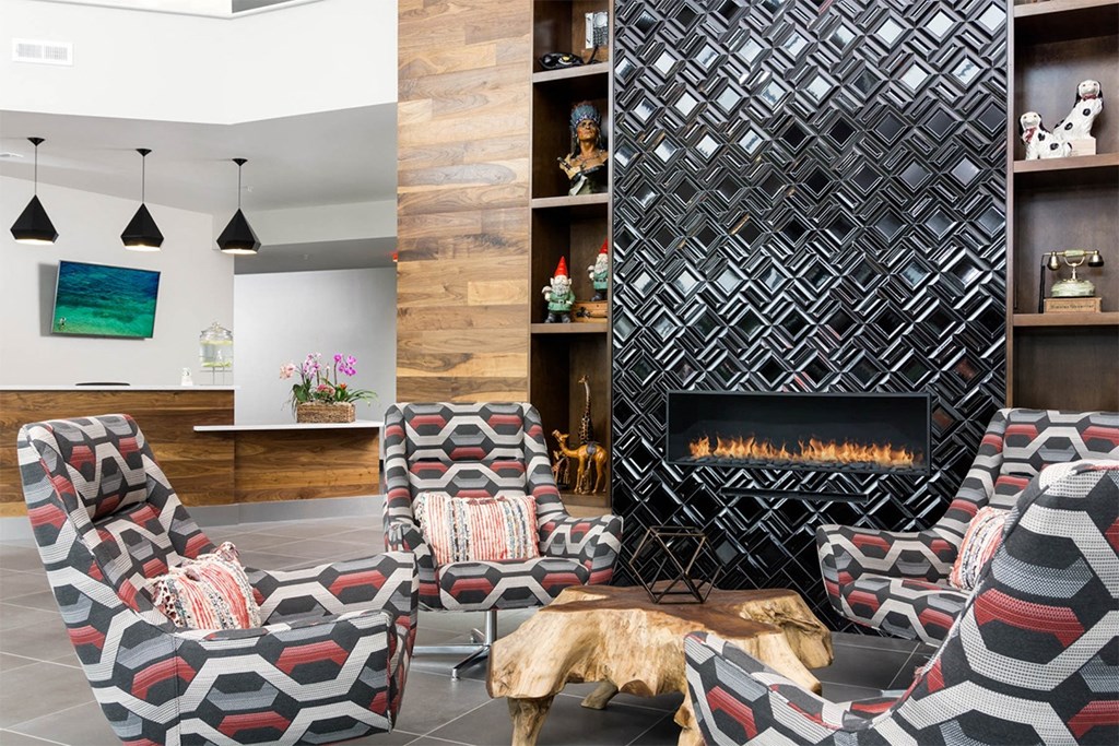 A modern living room with a fireplace and patterned chairs.