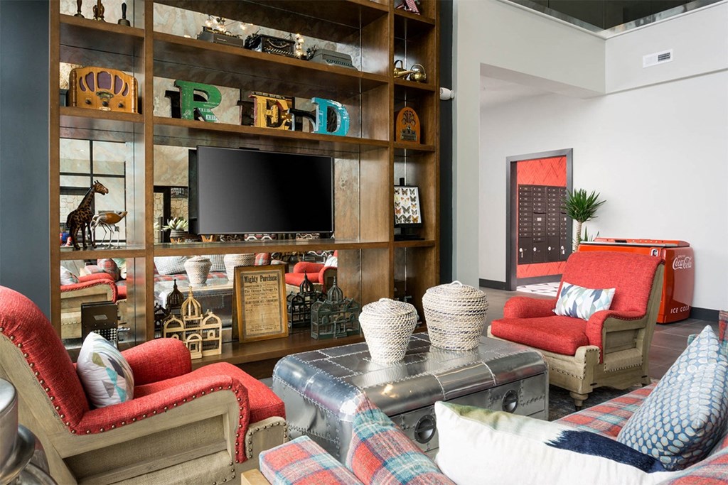A living room with a red chair and a glass coffee table.
