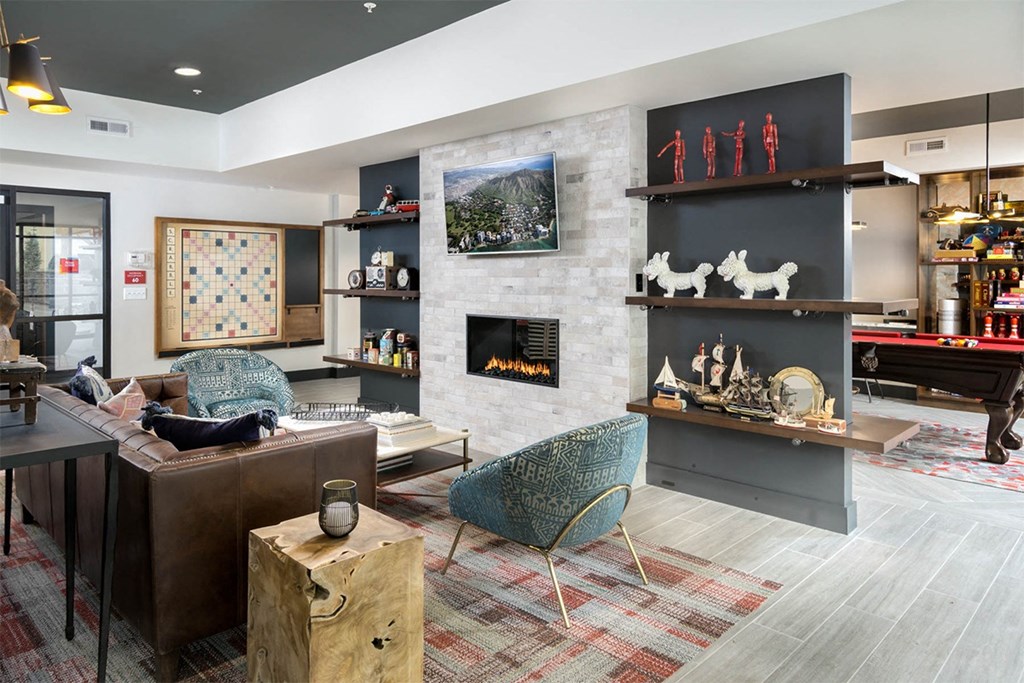 A living room with a fireplace and a painting of a dog on the wall.