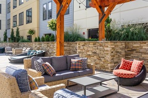 A patio with a couch, chairs, and a table.