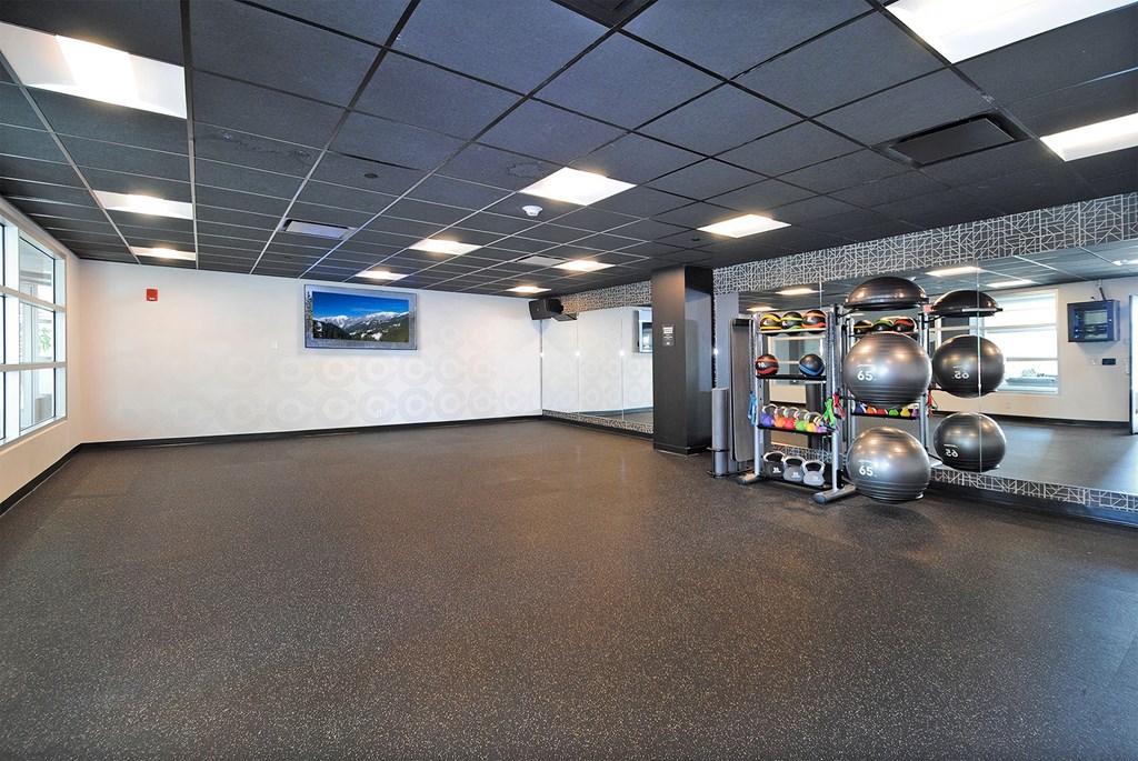 A gym with a variety of equipment including kettlebells and dumbbells.