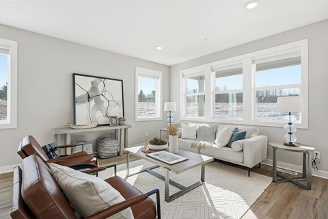 A living room with a brown leather chair and a glass coffee table.