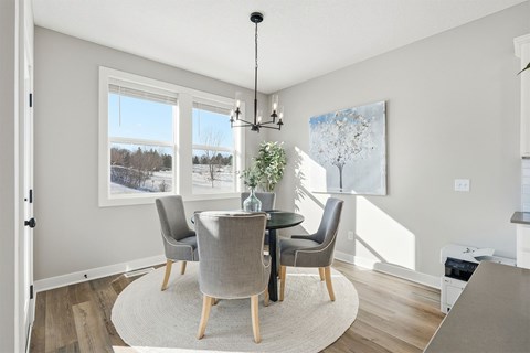 A dining room with a table and chairs.