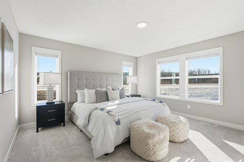 A bedroom with a large bed and a window overlooking a snowy landscape.