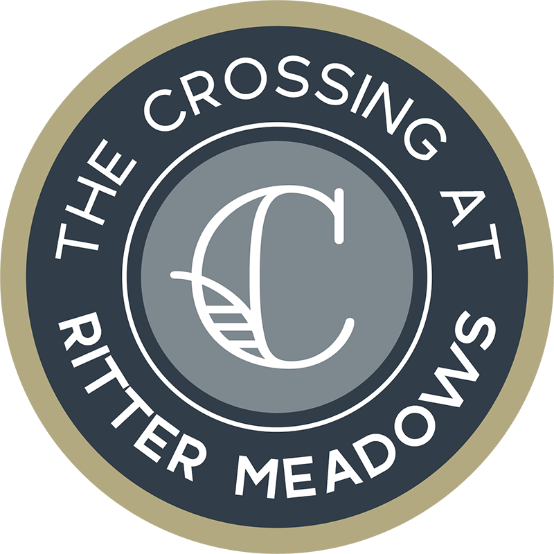 A logo with the text "The Crossing at Ritter Meadows" and a graphic of a leaf and a letter "C".