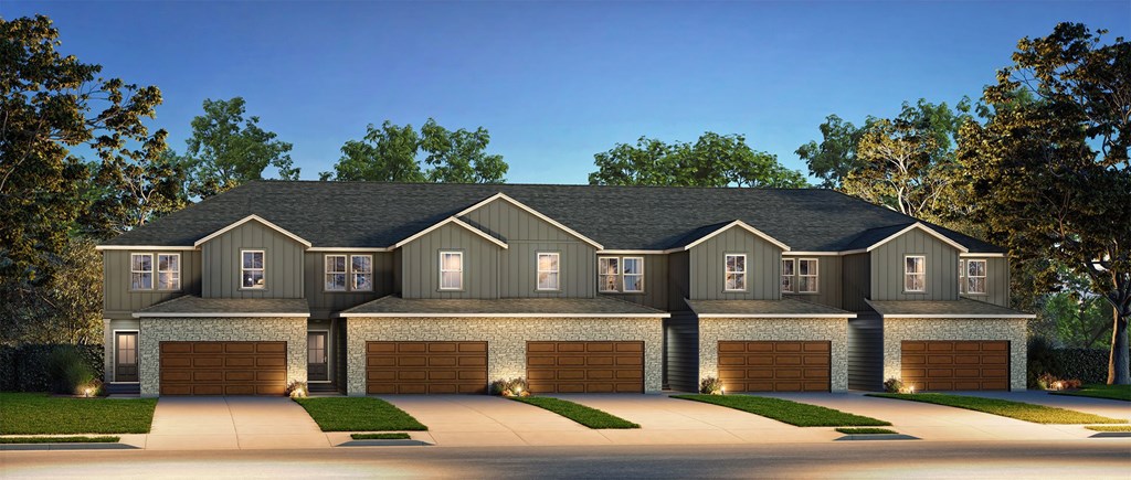 A large, two-story house with a dark grey exterior and a black roof.