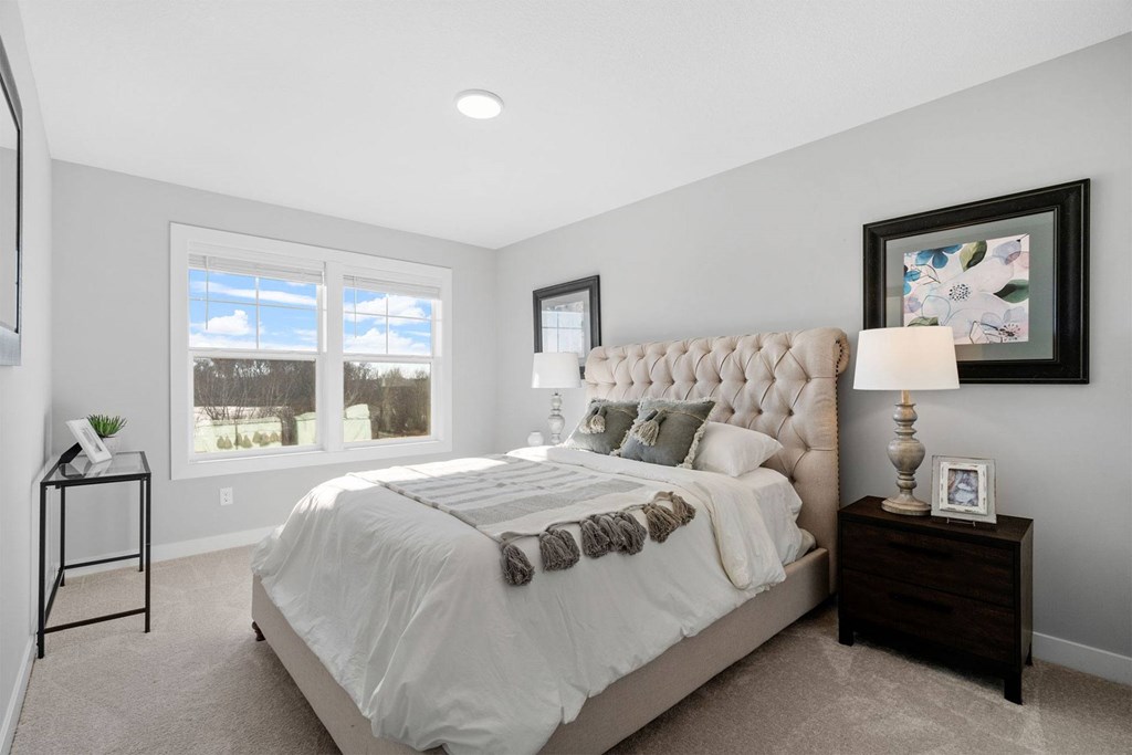 A bedroom with a large bed and a window overlooking a snowy landscape.
