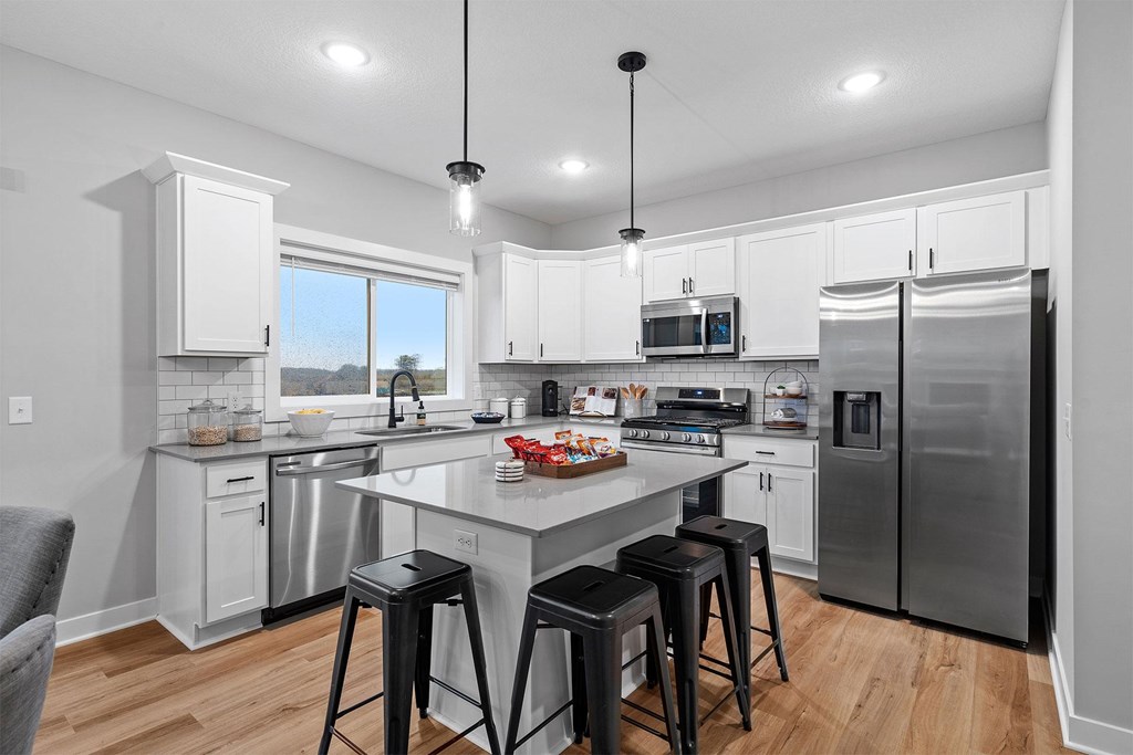 A kitchen with a large island and stools.