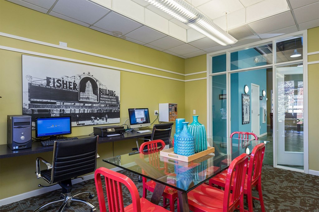 A room with a desk, chairs and a computer.