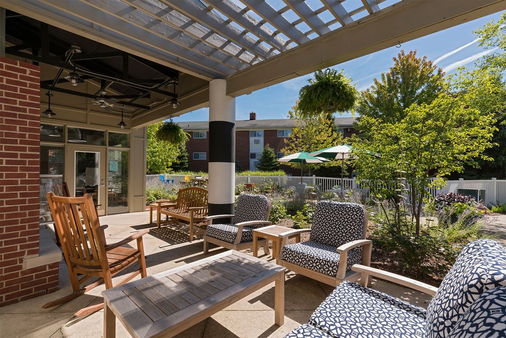 A patio with a table and chairs under a roof.