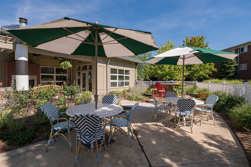 A patio with a table and chairs under umbrellas.