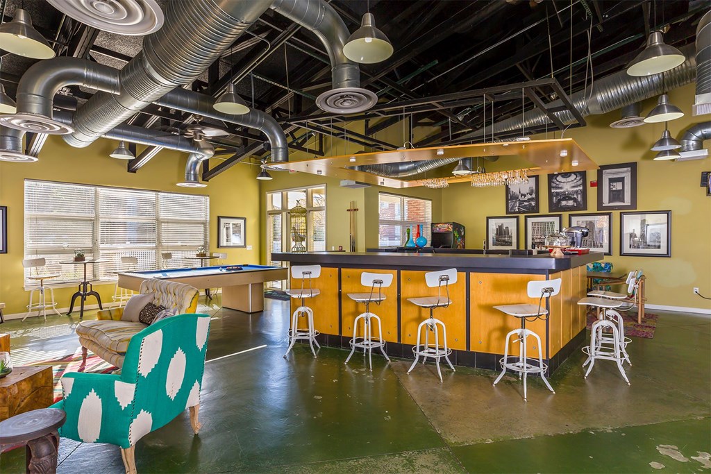 A room with a yellow bar and a green and white chair.