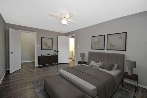 A bedroom with a large bed and a ceiling fan.