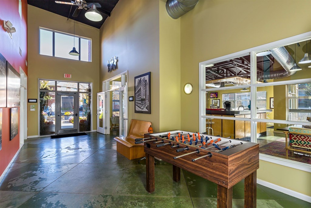 A foosball table is in the middle of a room with a green floor.