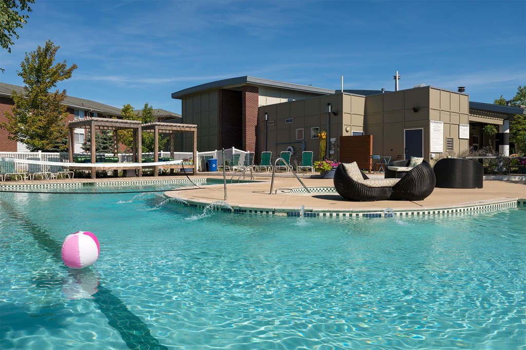 A pool with a pink ball floating in the water.