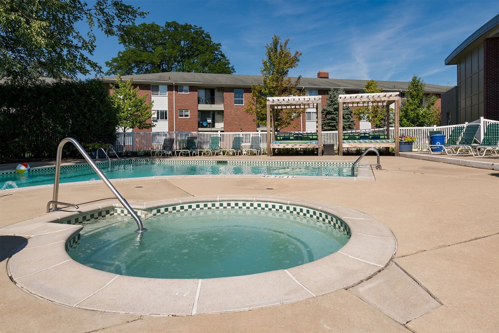 A round hot tub sits in the middle of a pool.