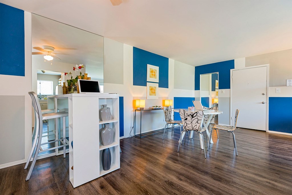 A room with a dining table and chairs.
