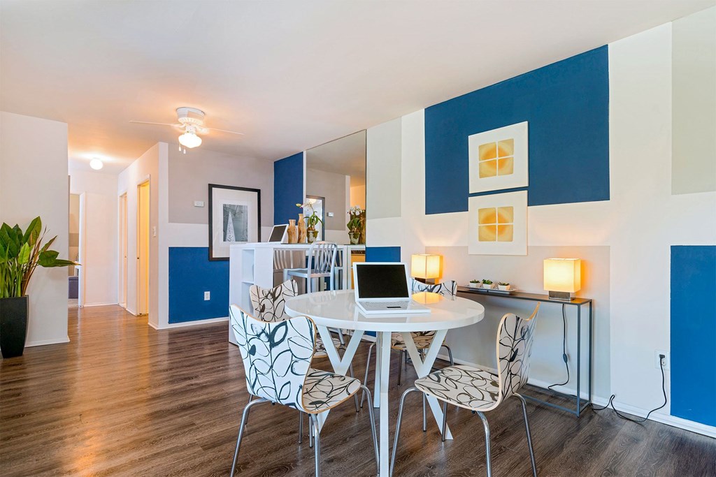 A dining room with a white table and chairs.