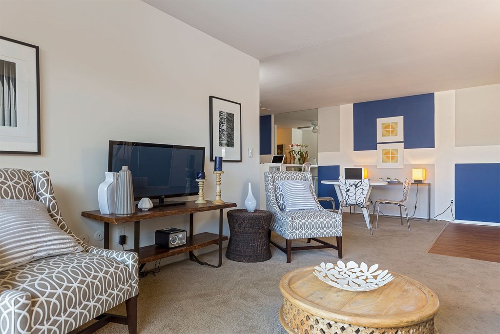 A living room with a television and a patterned sofa.