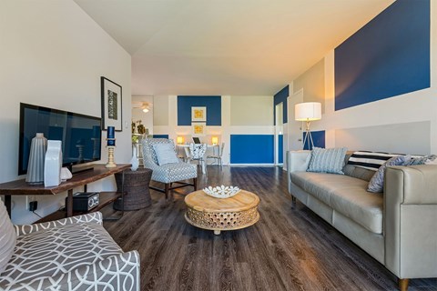A living room with a patterned couch and a wooden coffee table.