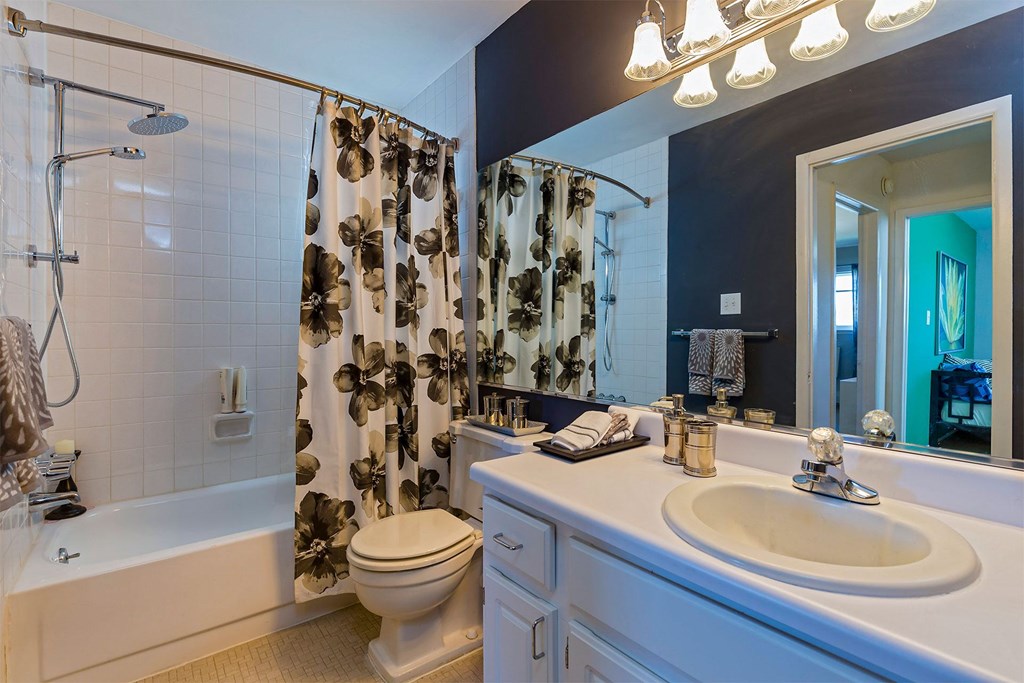 A white bathroom with a shower, toilet, and sink.