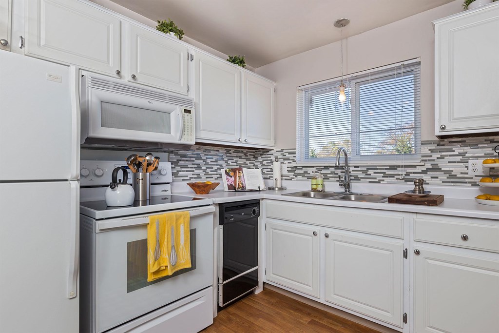 A kitchen with white appliances and cabinets.