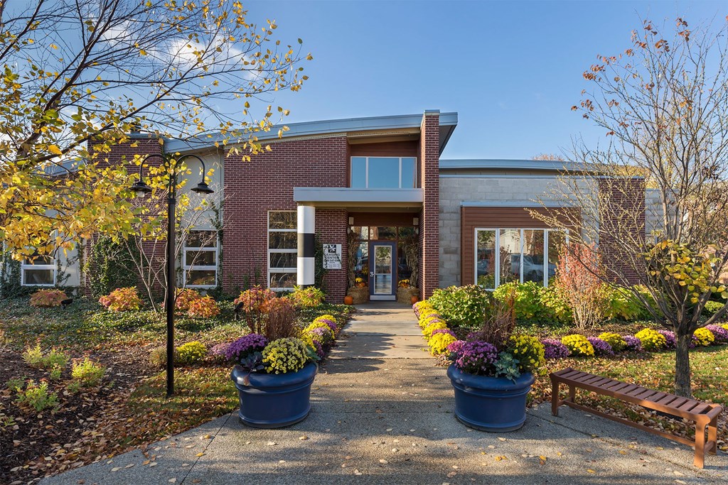 A building with a brick facade and a wooden bench in front.