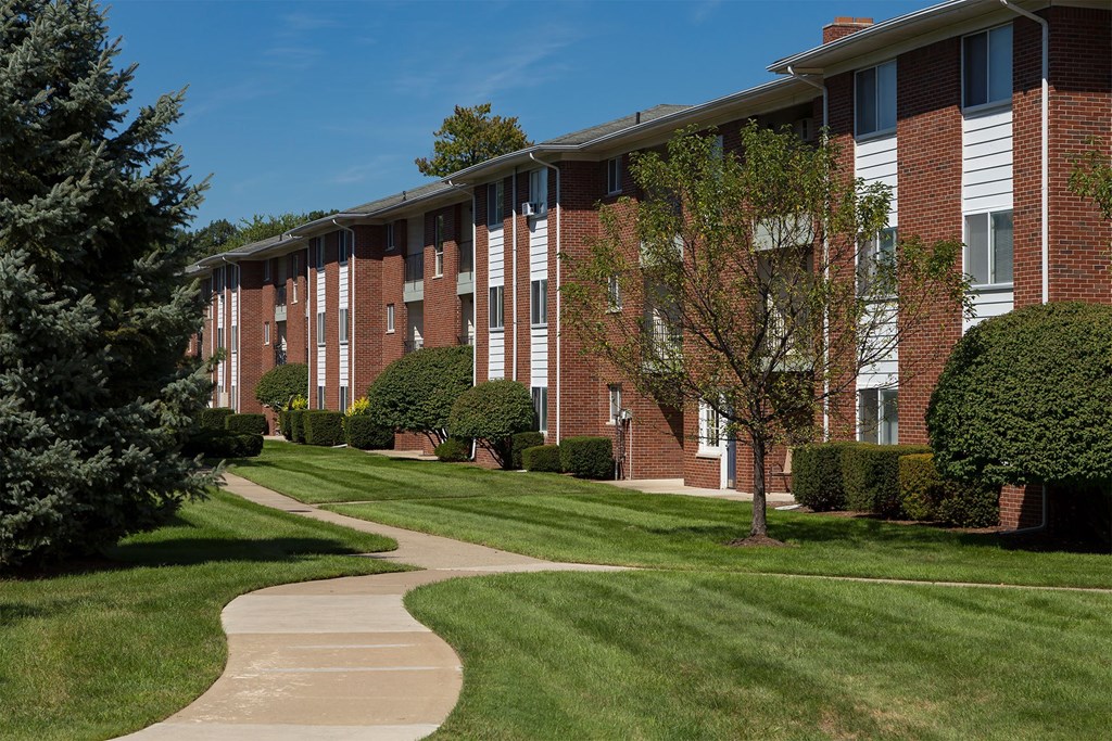 A long building with a red brick exterior and a white trim around the windows.