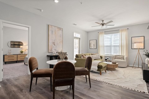 A modern living room with a dining table and chairs.