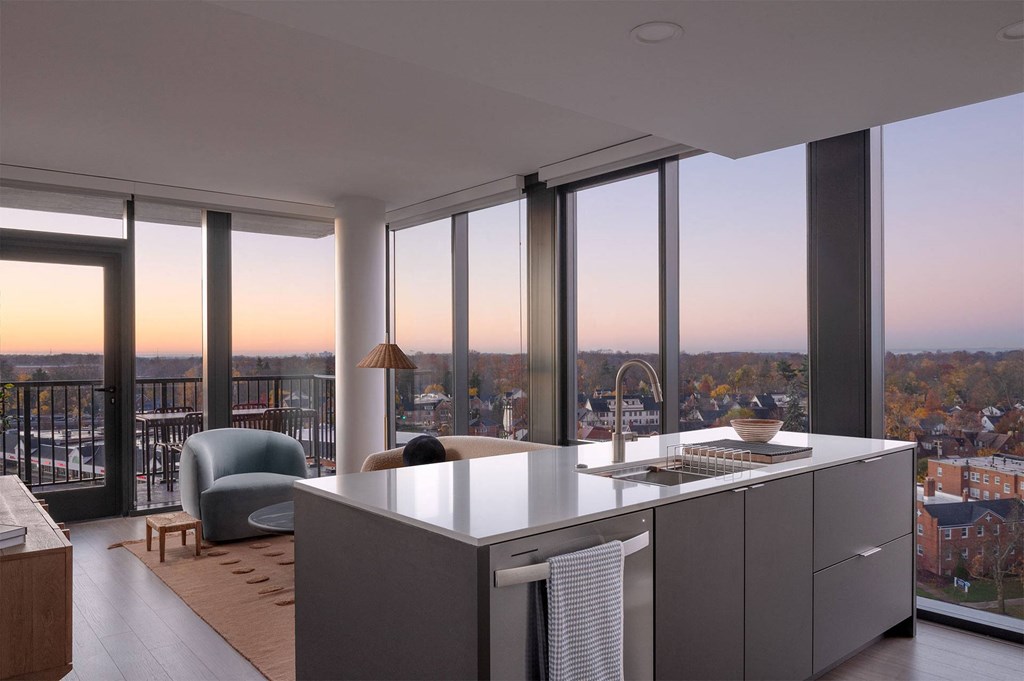 A modern kitchen with a large island and a view of the city.