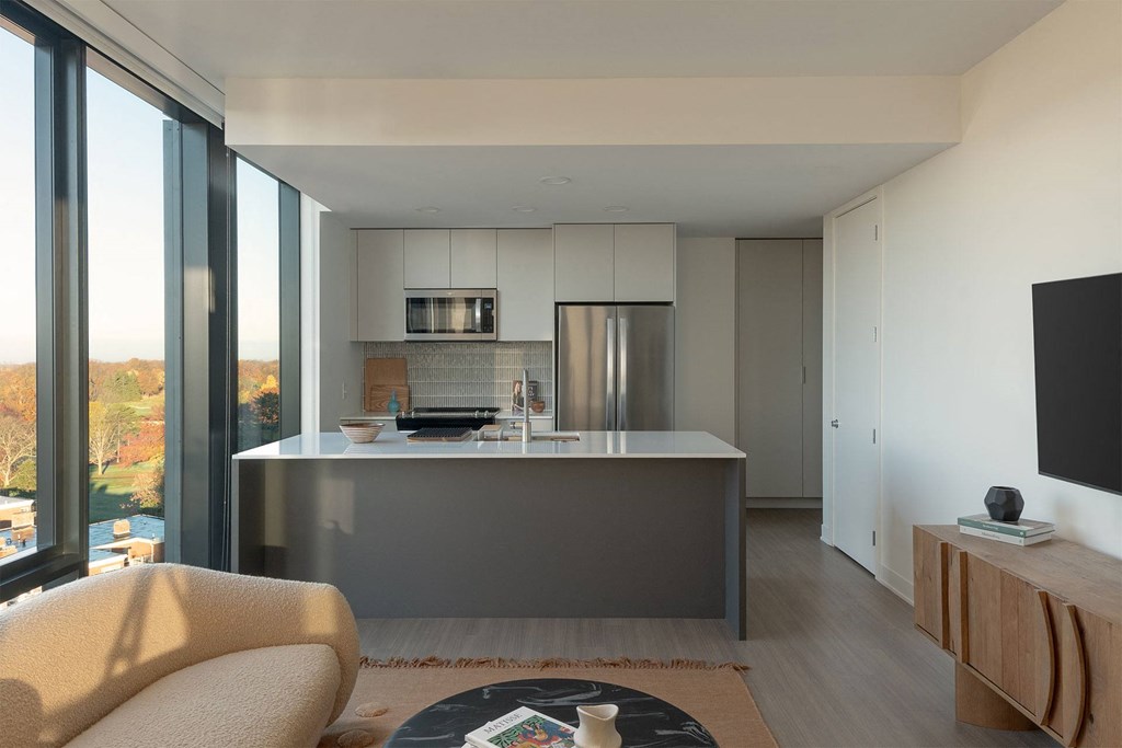 A modern kitchen with a large island and a chair.