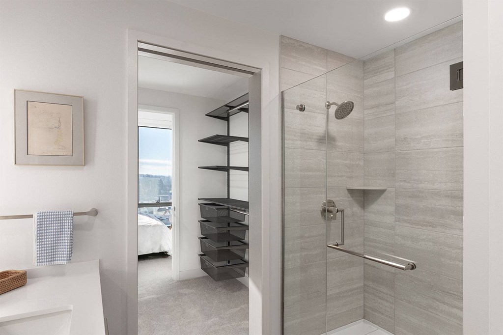 A bathroom with a walk in shower and a towel rack.