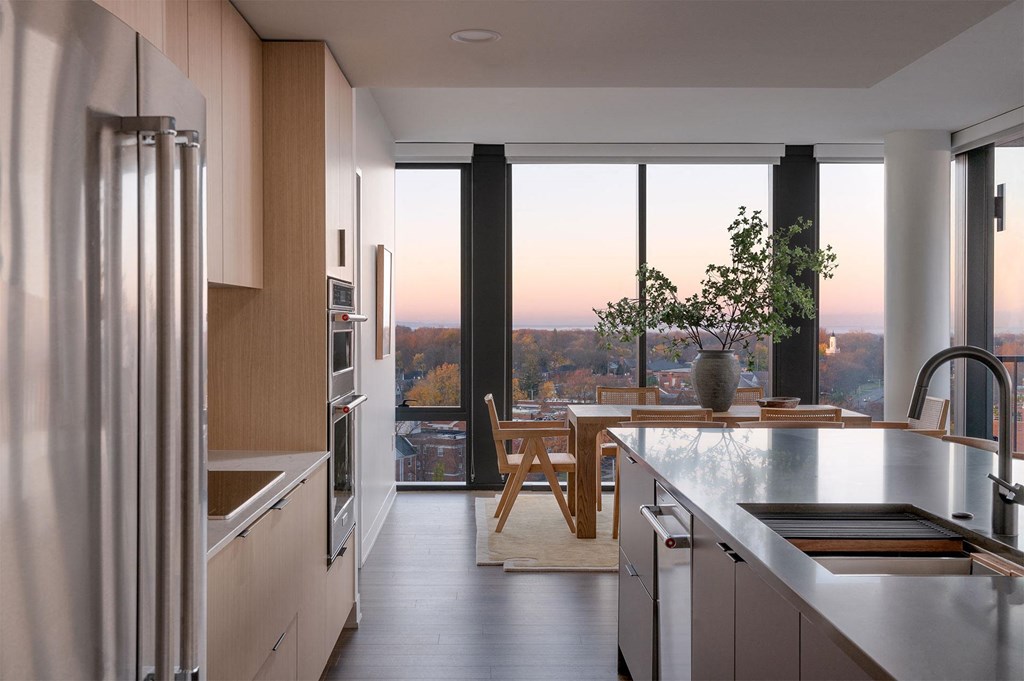 A modern kitchen with stainless steel appliances and a view of the city.