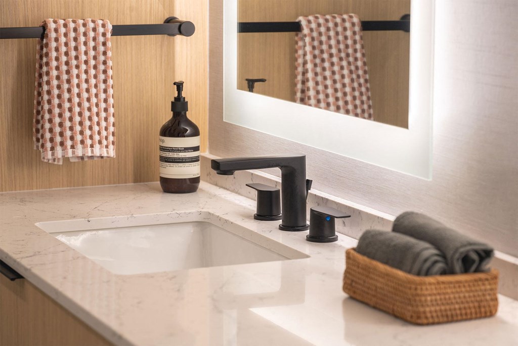 A bathroom with a white sink and a mirror.
