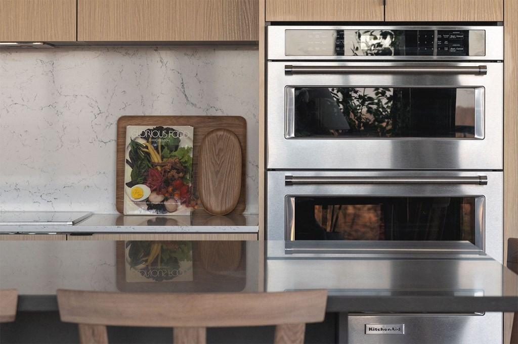 A kitchen with a wooden cutting board and a fridge with a magnet on it.