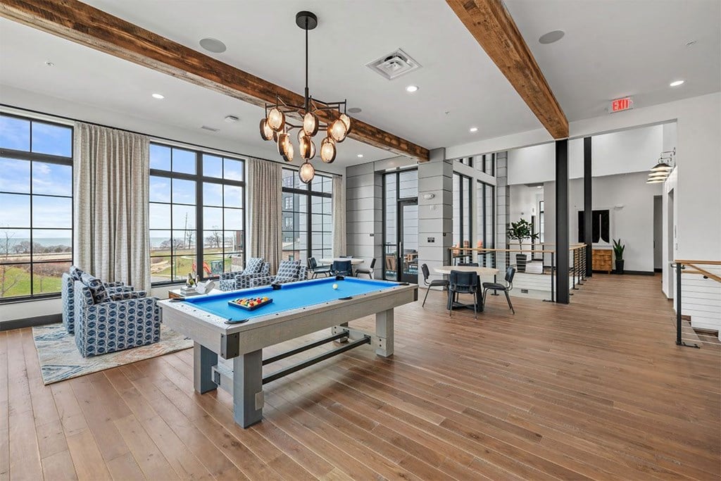 A room with a pool table and a view of the outside.