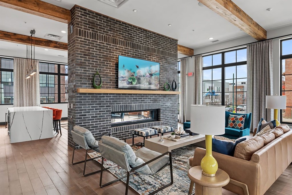 A living room with a fireplace and a painting above it.